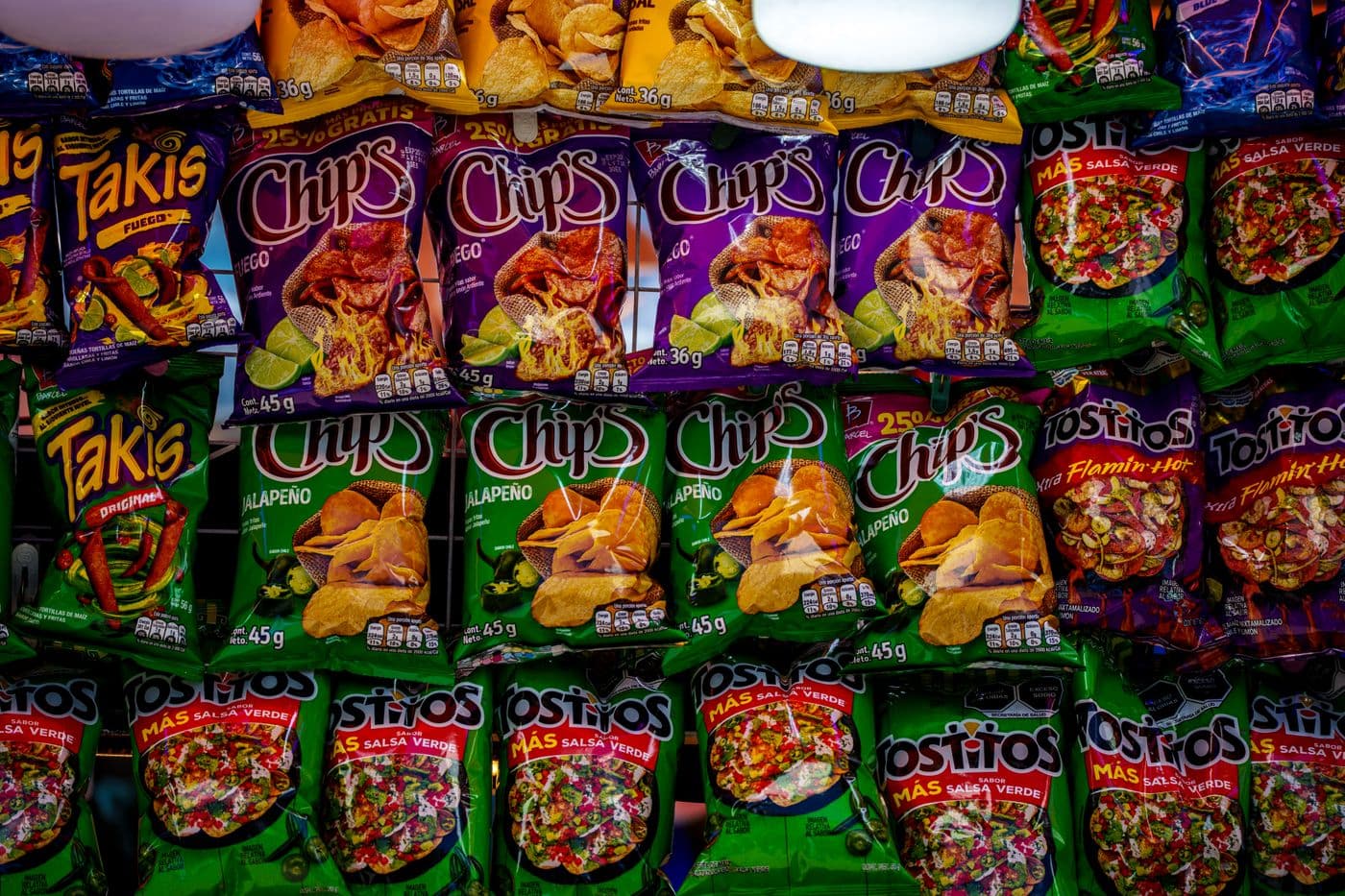 A colorful shelf of chips and snacks stocked at the store